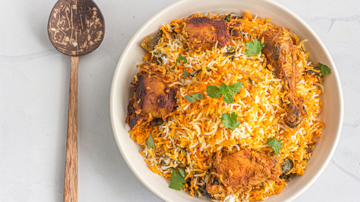 Layering rice and chicken with saffron milk for biryani